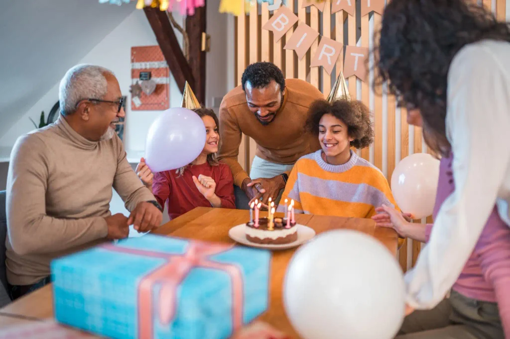 Happy birthday wishes simple text for family members with a family birthday celebration, cake, and balloons.