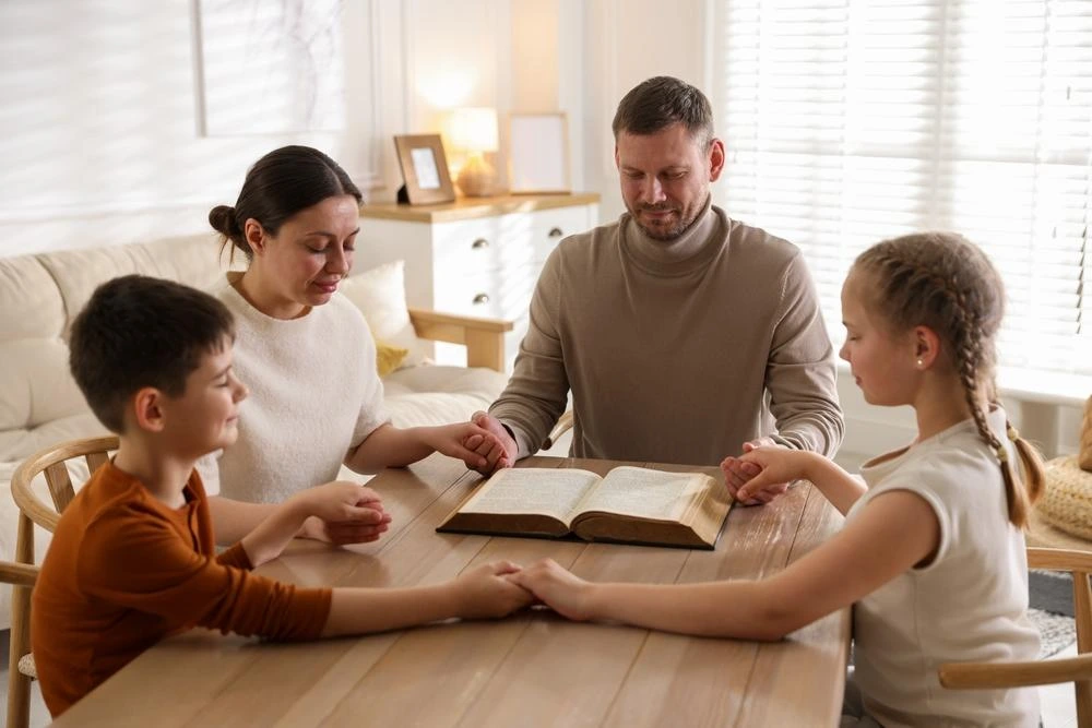 Family members holding hands in prayer during a peaceful Friday morning.