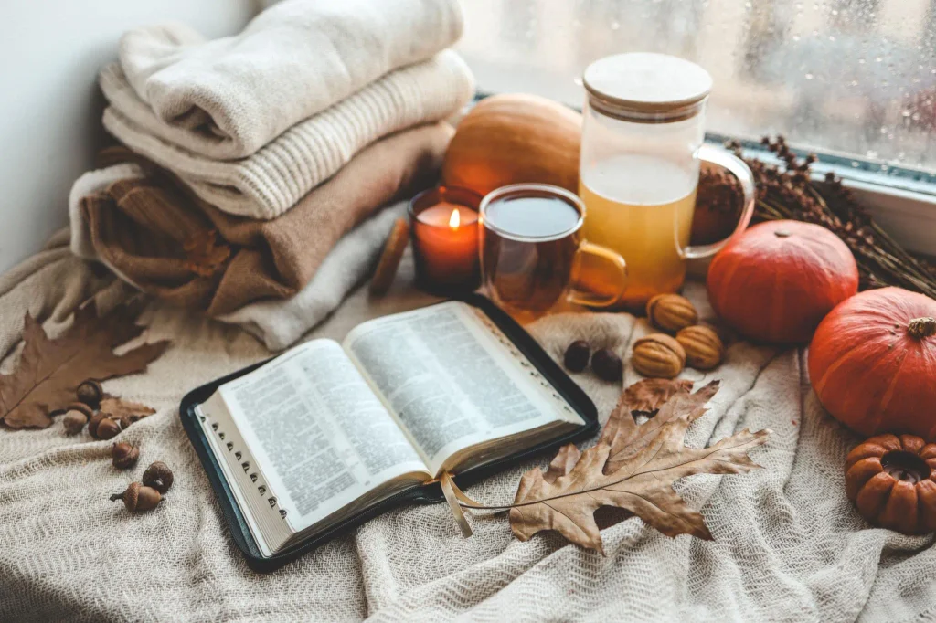 Happy October Blessings with a peaceful October prayer, open Bible, glowing candle, and autumn flowers.